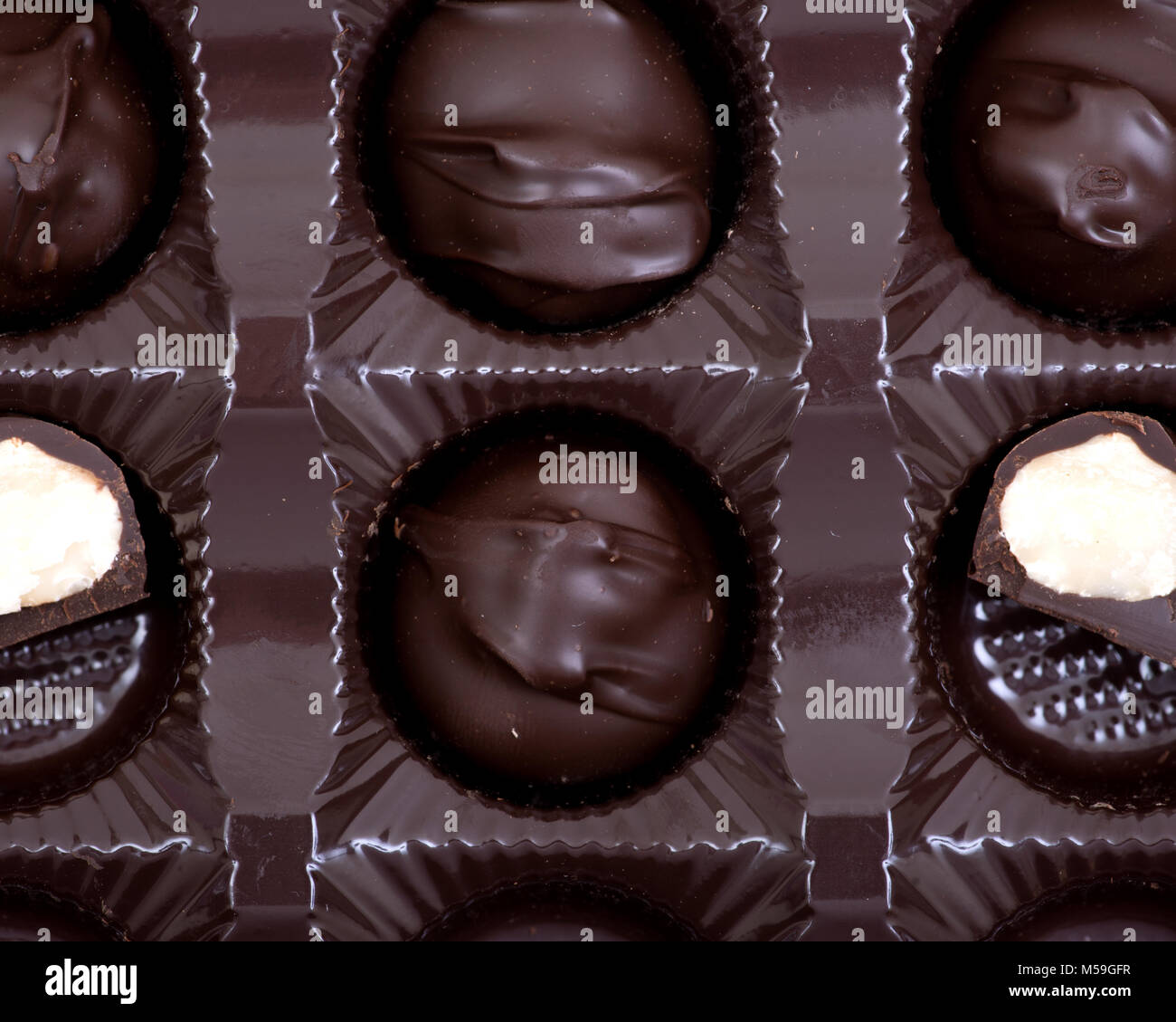 Dark chocolate covered macadamia nuts in plastic packaging Stock Photo