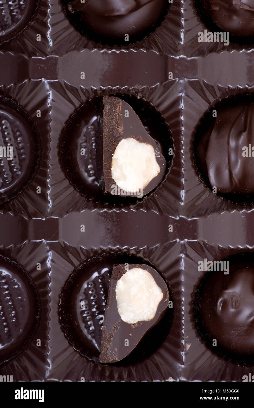 Dark chocolate covered macadamia nuts in plastic packaging Stock Photo