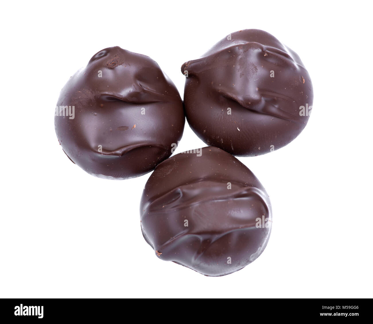 Dark chocolate covered macadamia nuts isolated on white background