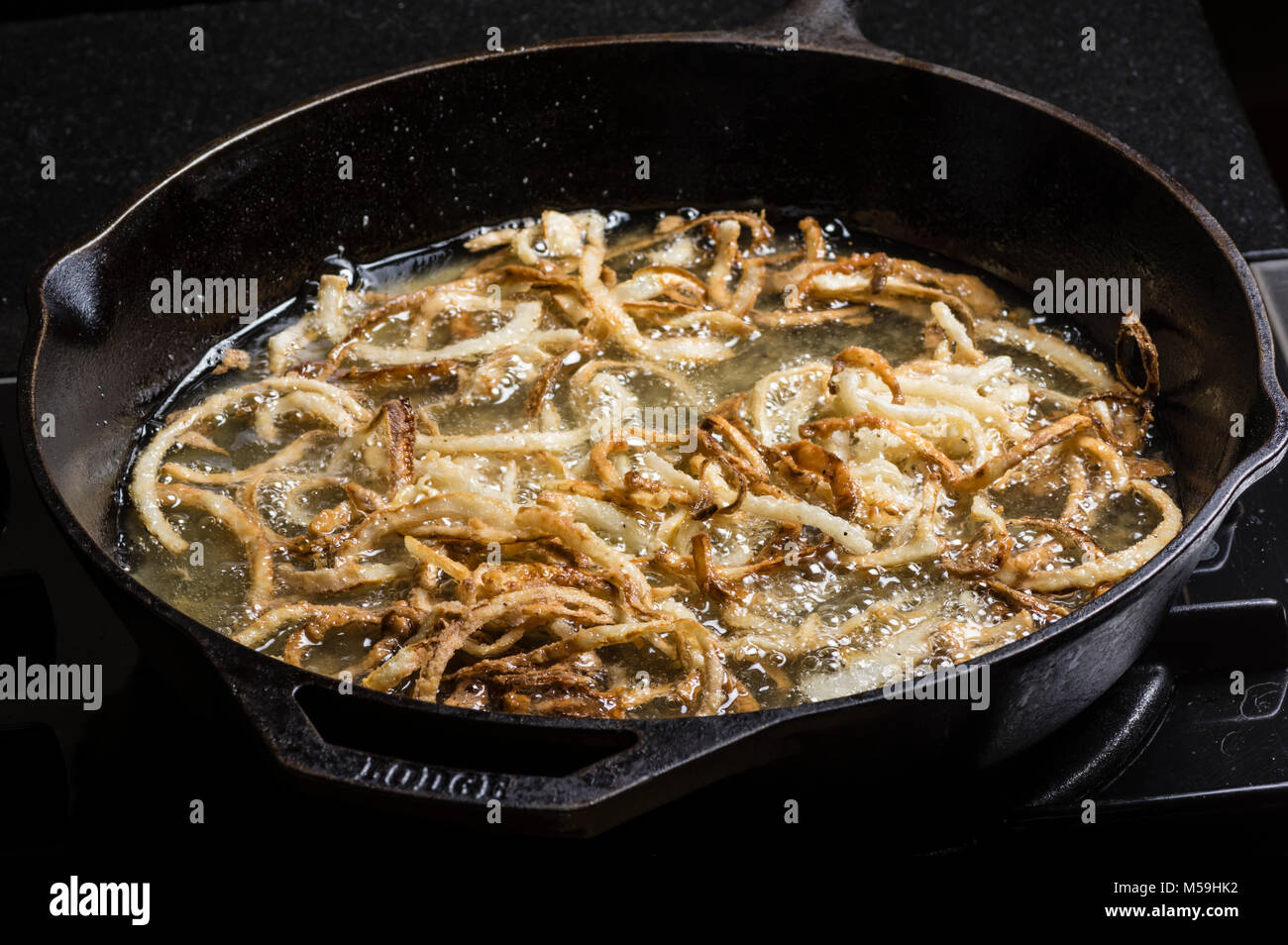 Frying onion rings in a cast iron skillet Stock Photo Alamy