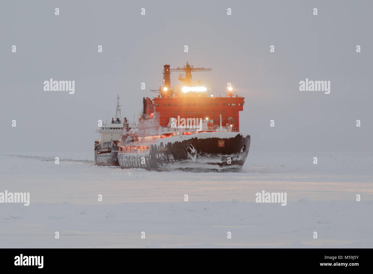 Pevek, Chukchi region, Russia - Pevek, November 30th, 2017: Ice breaker '50 years of the Victory' are towed by dry-cargo ship 'Valery Vasilev'. Stock Photo