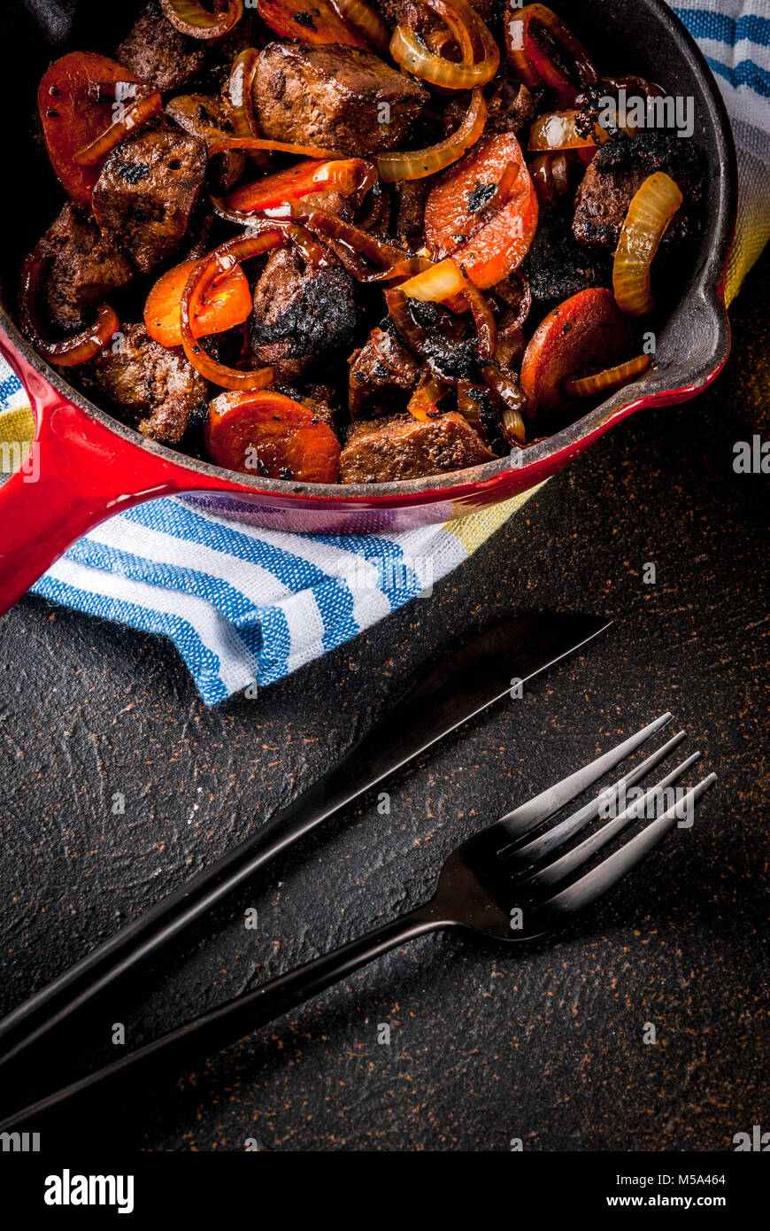 Roasted or grilled beef liver with onion and carrot in portioned frying