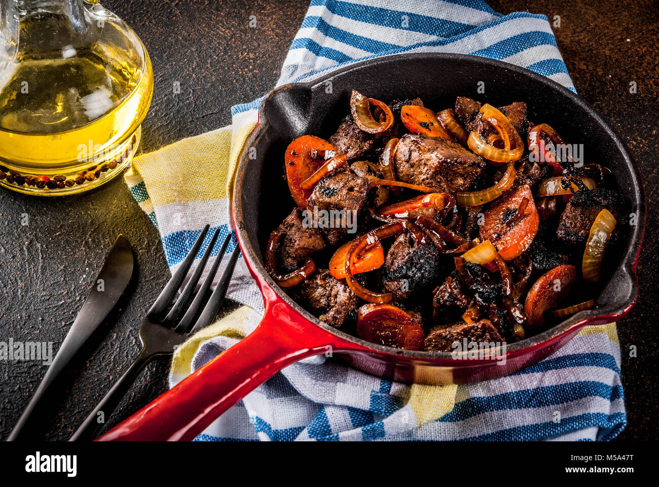 Roasted or grilled beef liver with onion and carrot in portioned frying