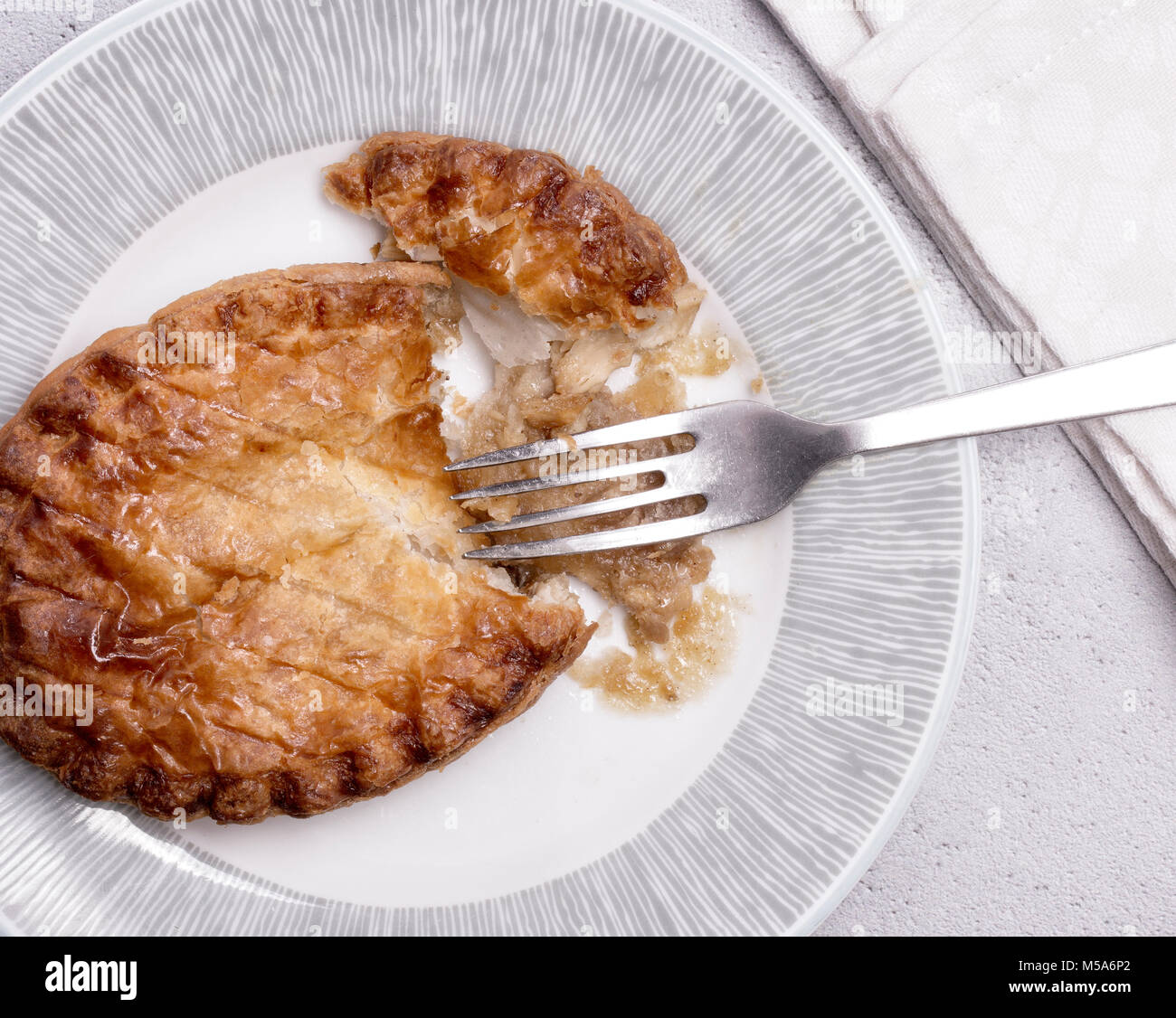 Overhead View of a Chicken pie on a plate with fork and napkin. Stock Photo