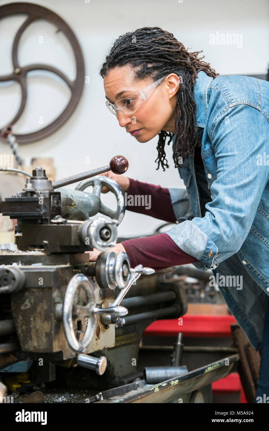 Woman Wearing Safety Glasses Standing In A Metal Workshop Working At Metal Lathe Machine Stock 6171