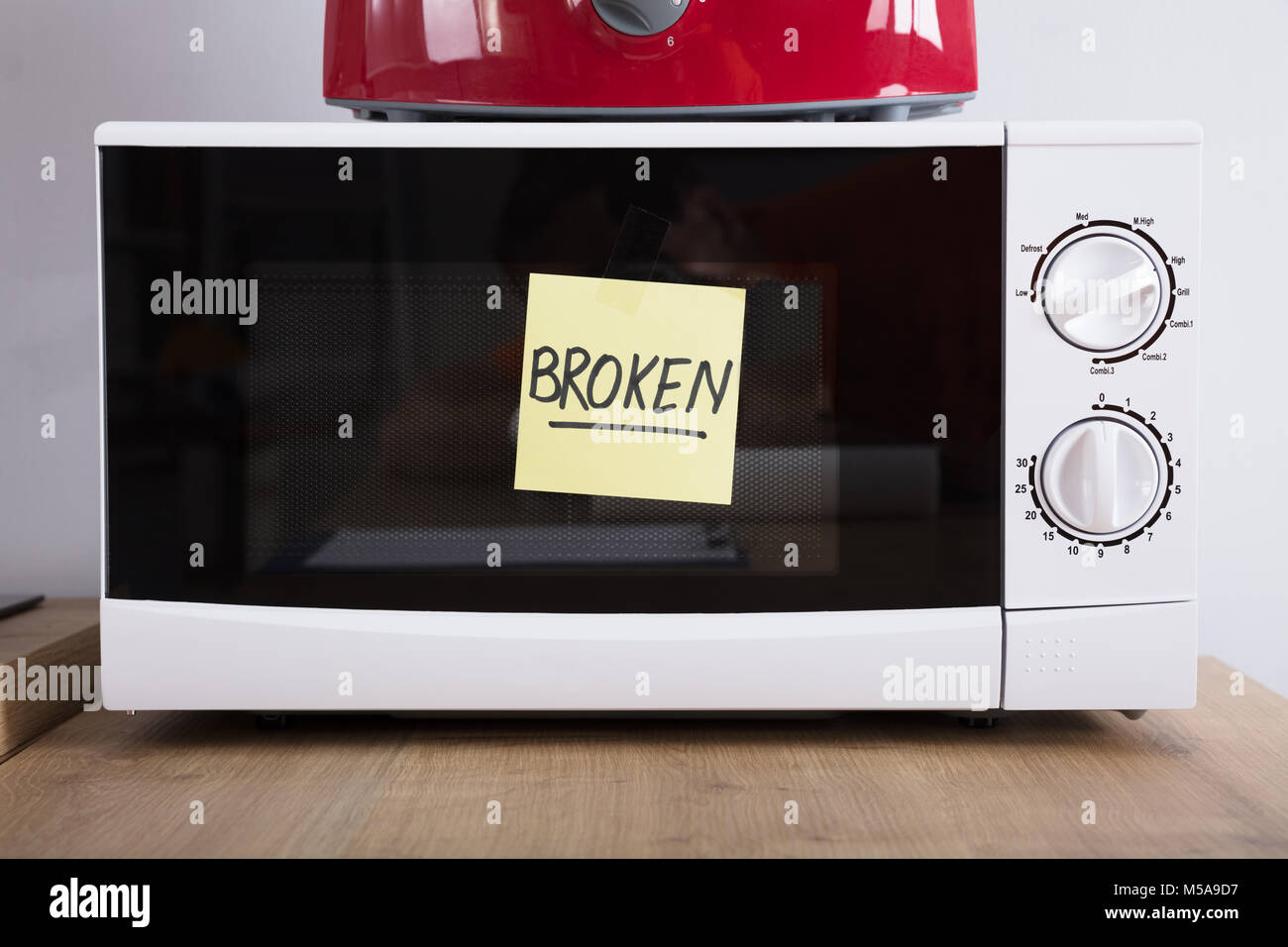 Close-up Of A Microwave Oven With Adhesive Notes Showing Broken Text Stock Photo