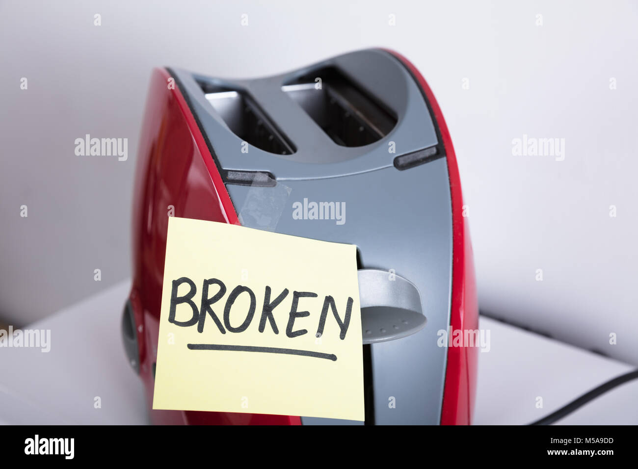 Close-up Of A Red Toaster With Adhesive Notes Showing Broken Text Stock Photo