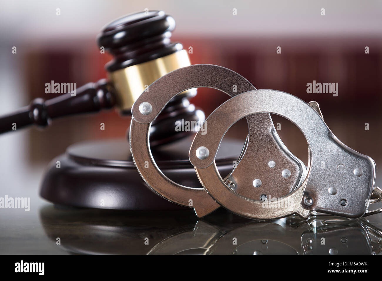 Close-up Of Handcuffs And Gavel In Courtroom Stock Photo