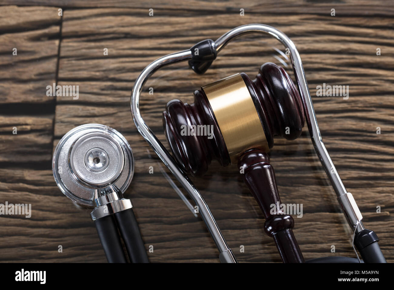 High Angle View Of Stethoscope And Gavel On Wooden Desk Stock Photo
