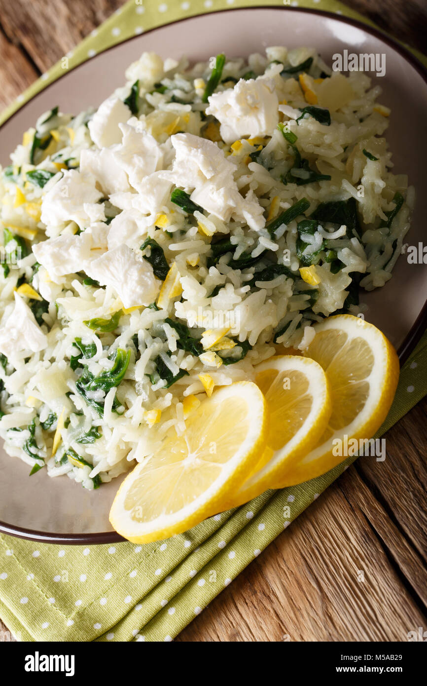 spanakorizo rice with spinach, lemon rind and feta close-up on a plate. vertical Stock Photo