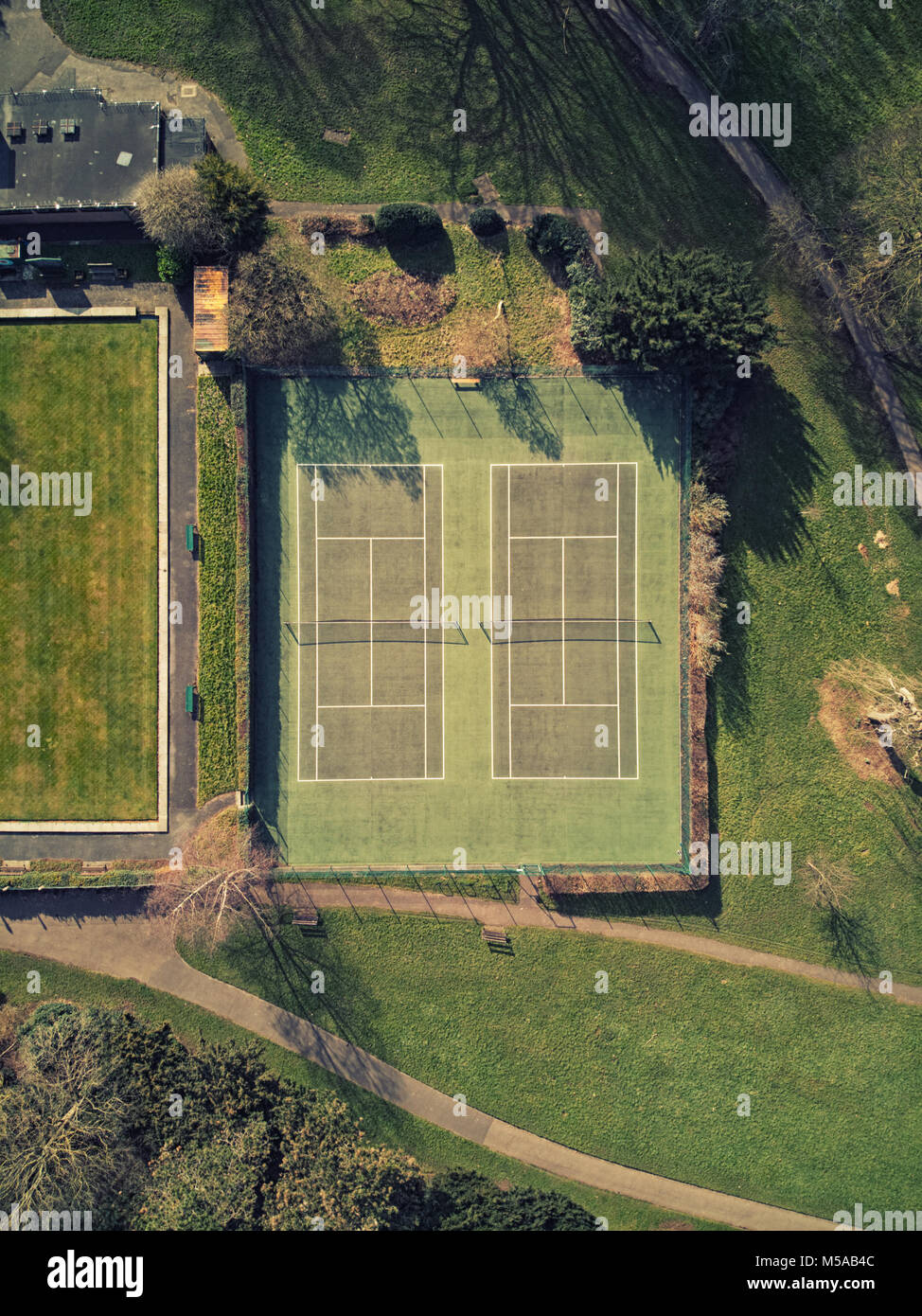Aerial view of Tennis courts on a sunny day, nets visible in shadow Stock Photo