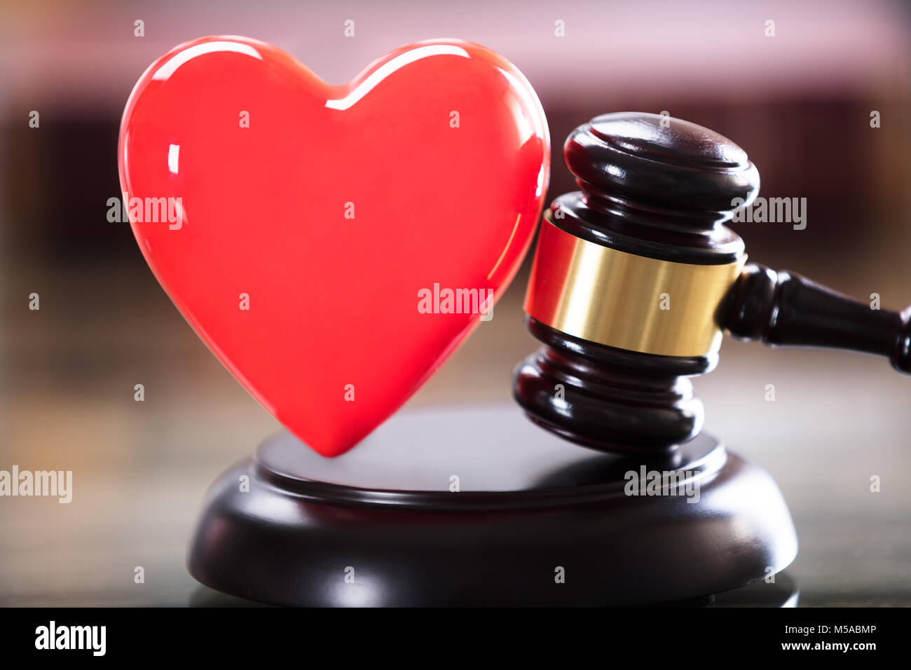 Close-up Of Red Heart And Gavel In Courtroom Stock Photo