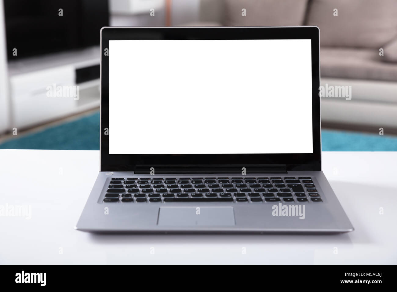 Close-up Of Laptop With Blank White Screen On Desk Stock Photo