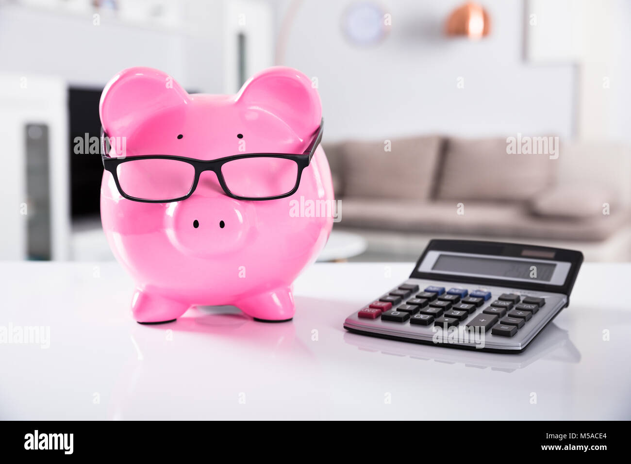 Close-up Of Pink Piggybank Wearing Spectacles With Calculator On Desk ...