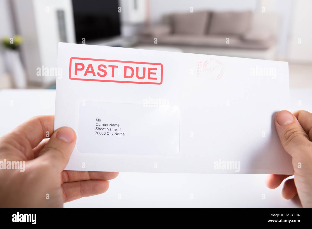 Close-up Of A Person's Hand Holding Past Due Bill Envelope Stock Photo