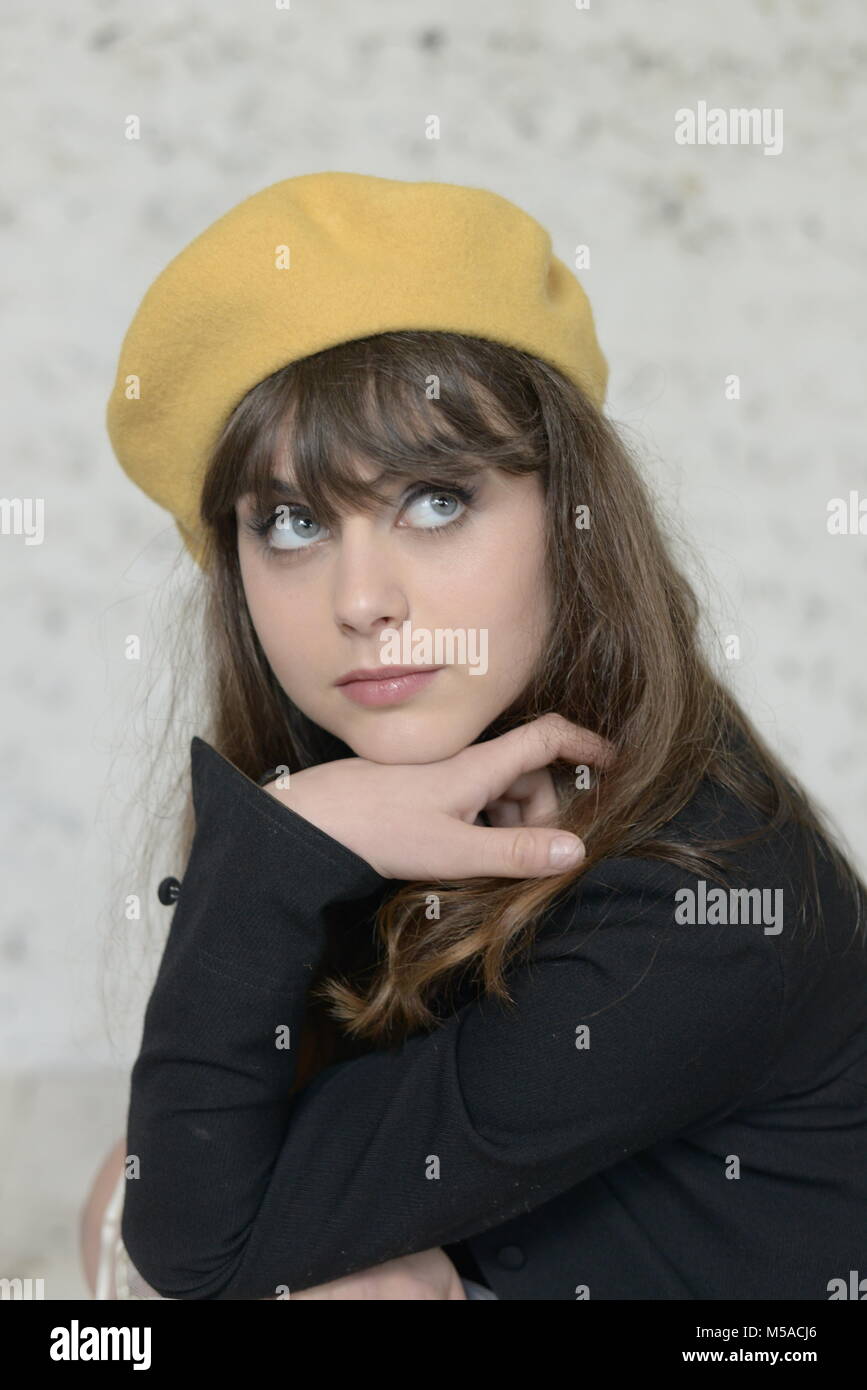 A Beautiful Blue Eyed Dark Haired Girl Wears A Yellow Berret