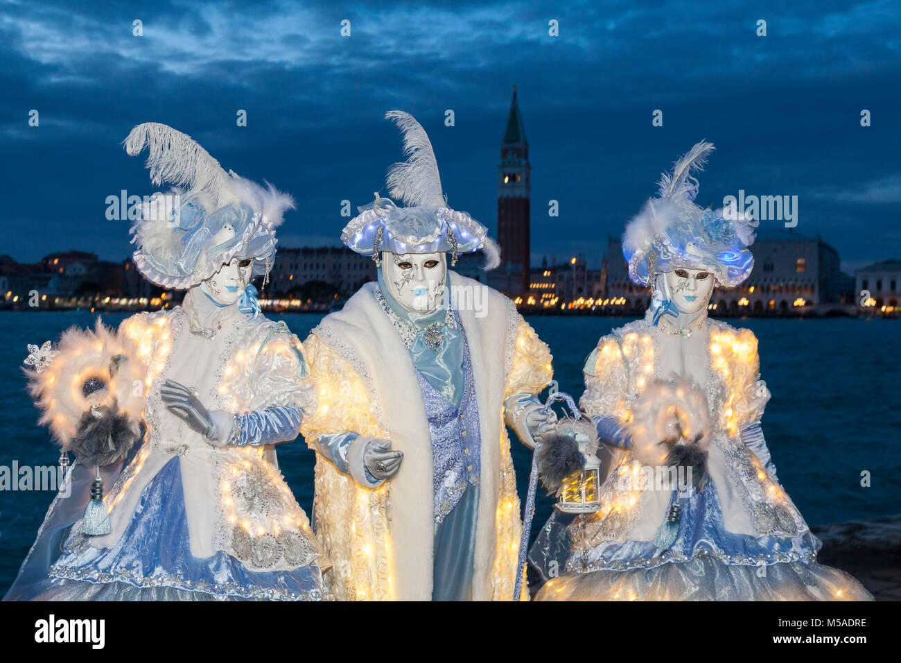 Venice Carnival At Night Venice Veneto Italy With Three People Wearing Illuminated Costumes Posing At Blue Hour With The Lagoon Campanile And Dog Stock Photo Alamy
