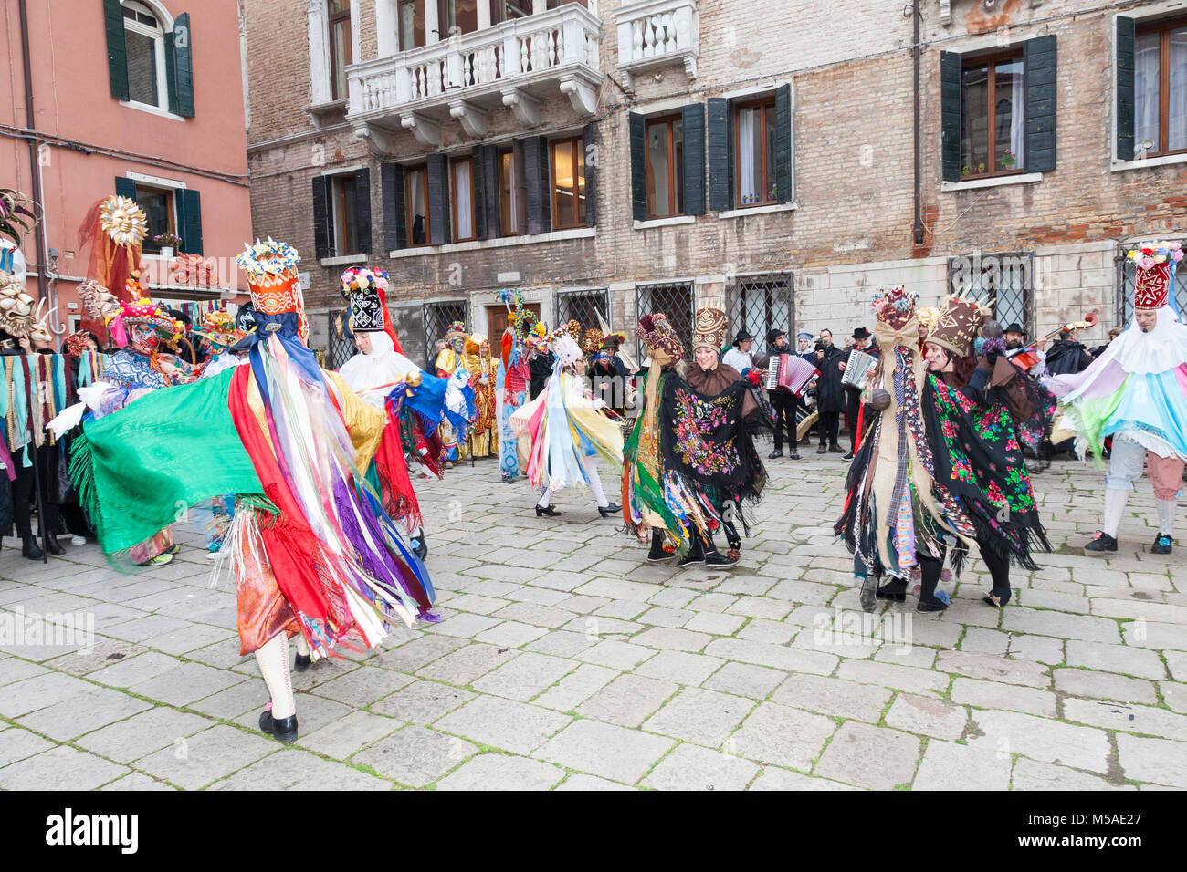 Beheading of The Bull Parade, Venice Carnival, Venice, Veneto, Italy with a troupe of colorful dancers performing in Campo San Maurizio, San Marco to  Stock Photo