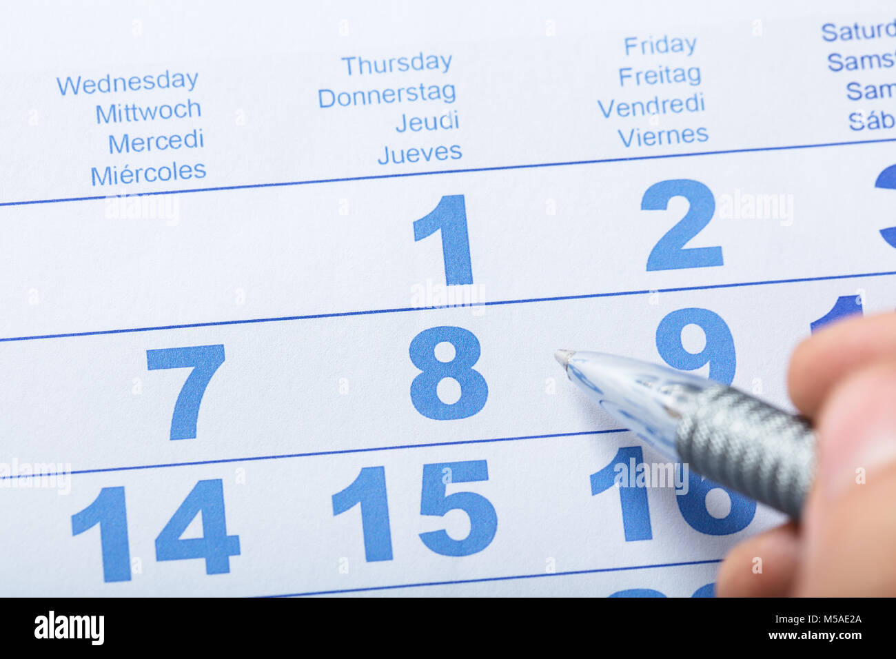 High Angle View Of Person's Finger With Pen Over Calendar Stock Photo