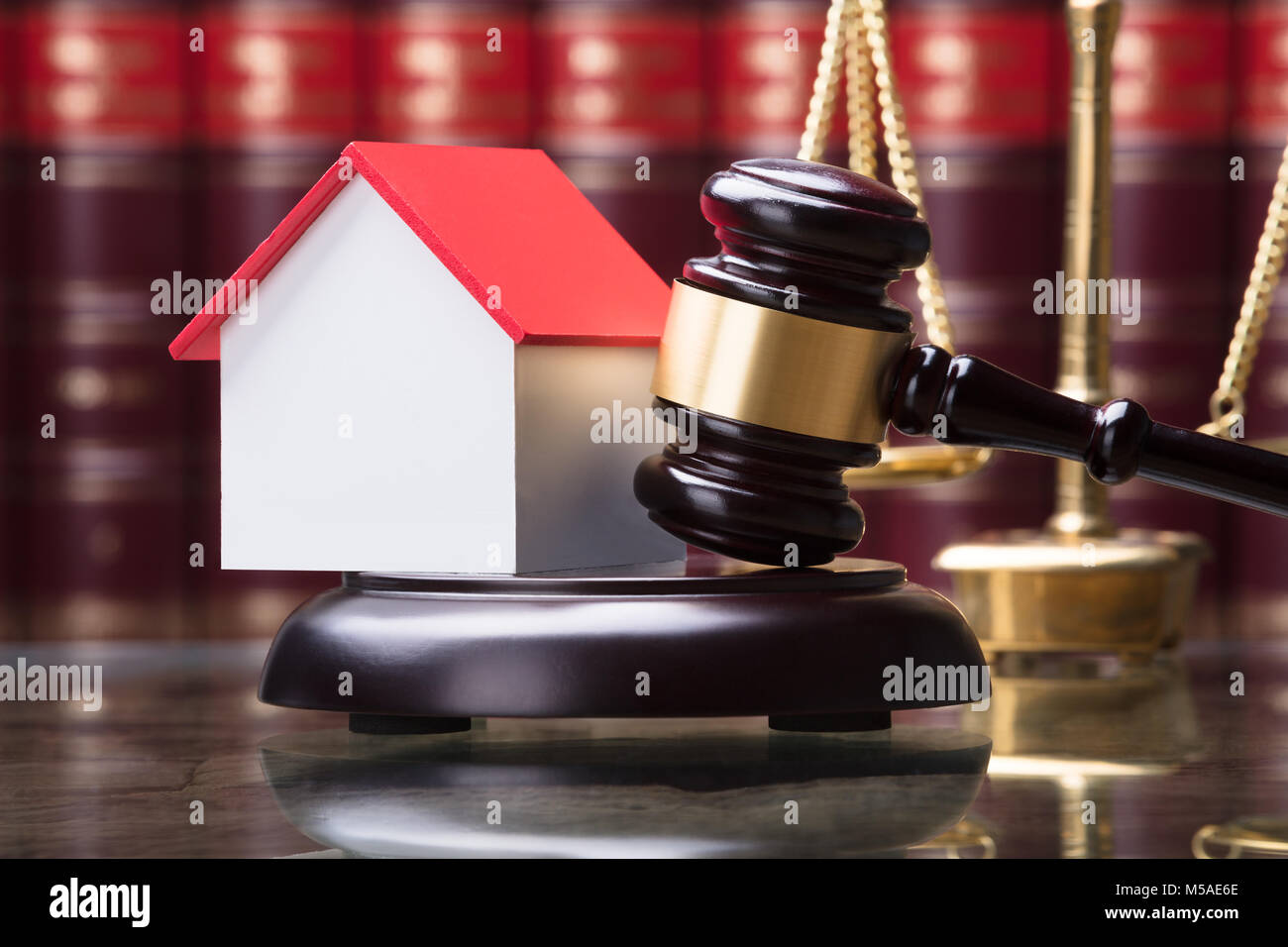 Close-up Of Gavel And House Model On Sounding Block Stock Photo