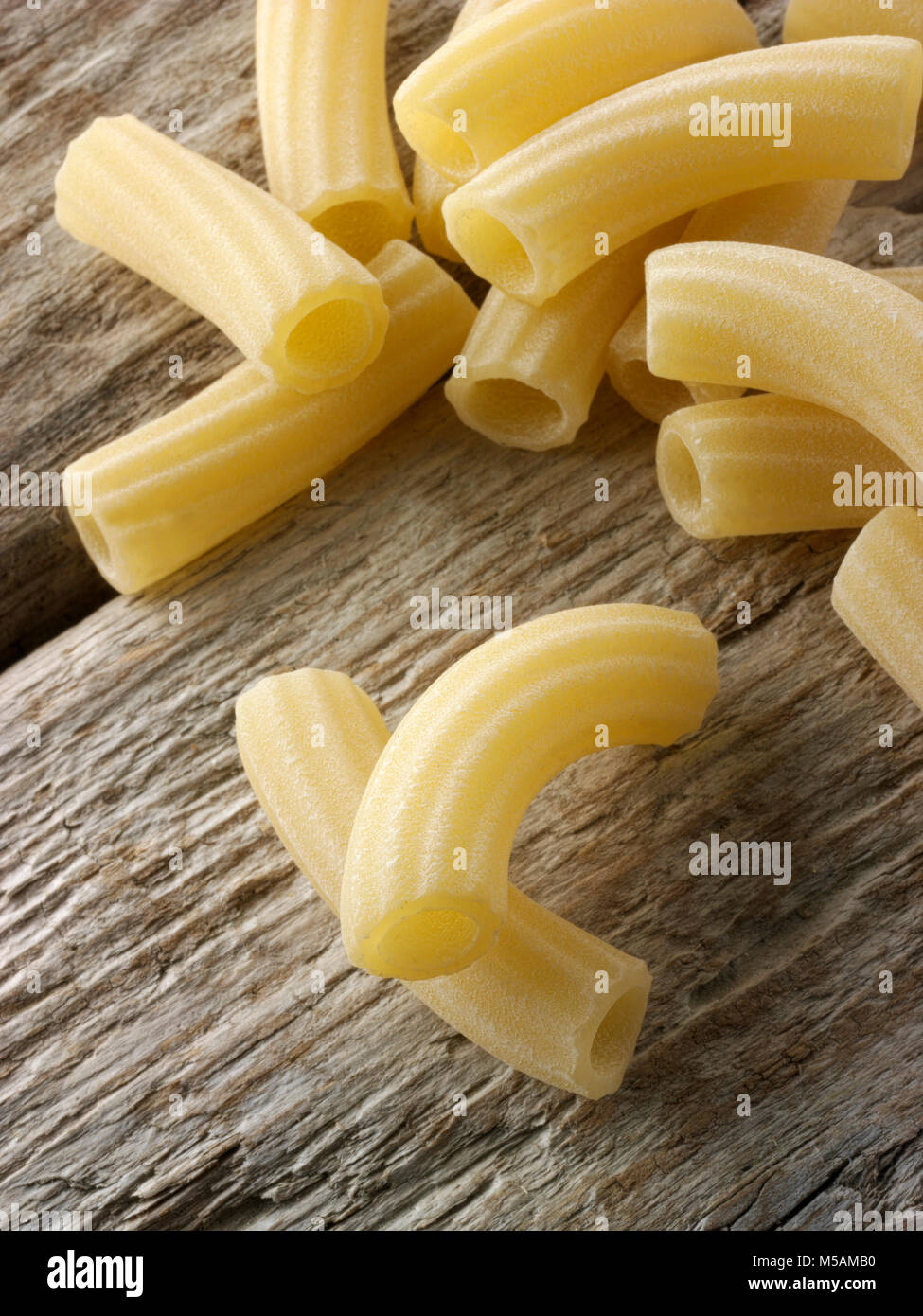 Traditional dried  Italaian Maccheroni di Toscana pasta close up in a rustic setting on wood Stock Photo