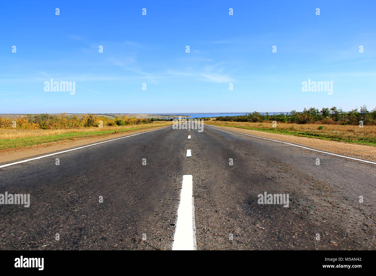 Summer landscape with line of road and blue sky Stock Photo - Alamy