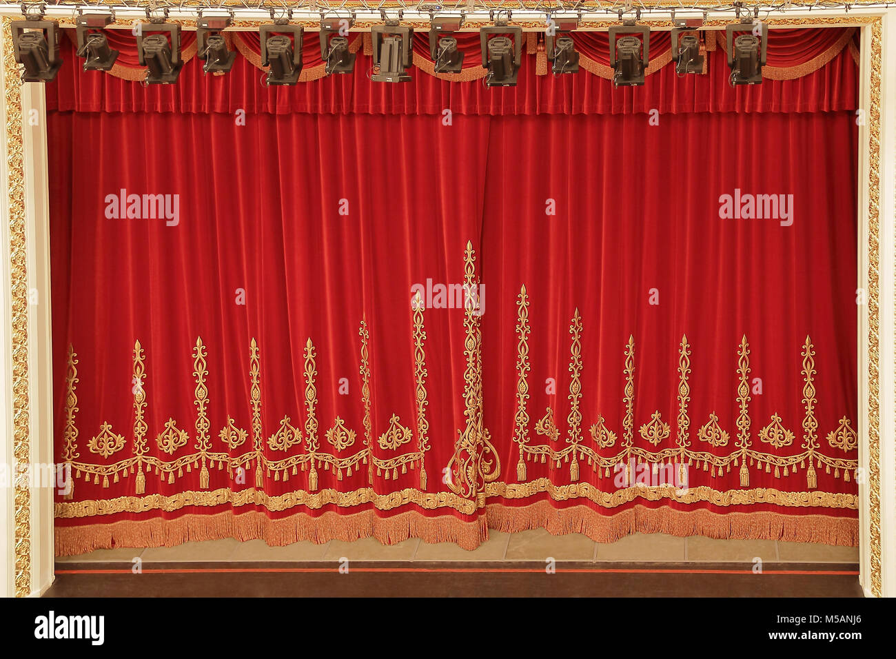Theatrical red velvet curtain with gold pattern Stock Photo - Alamy