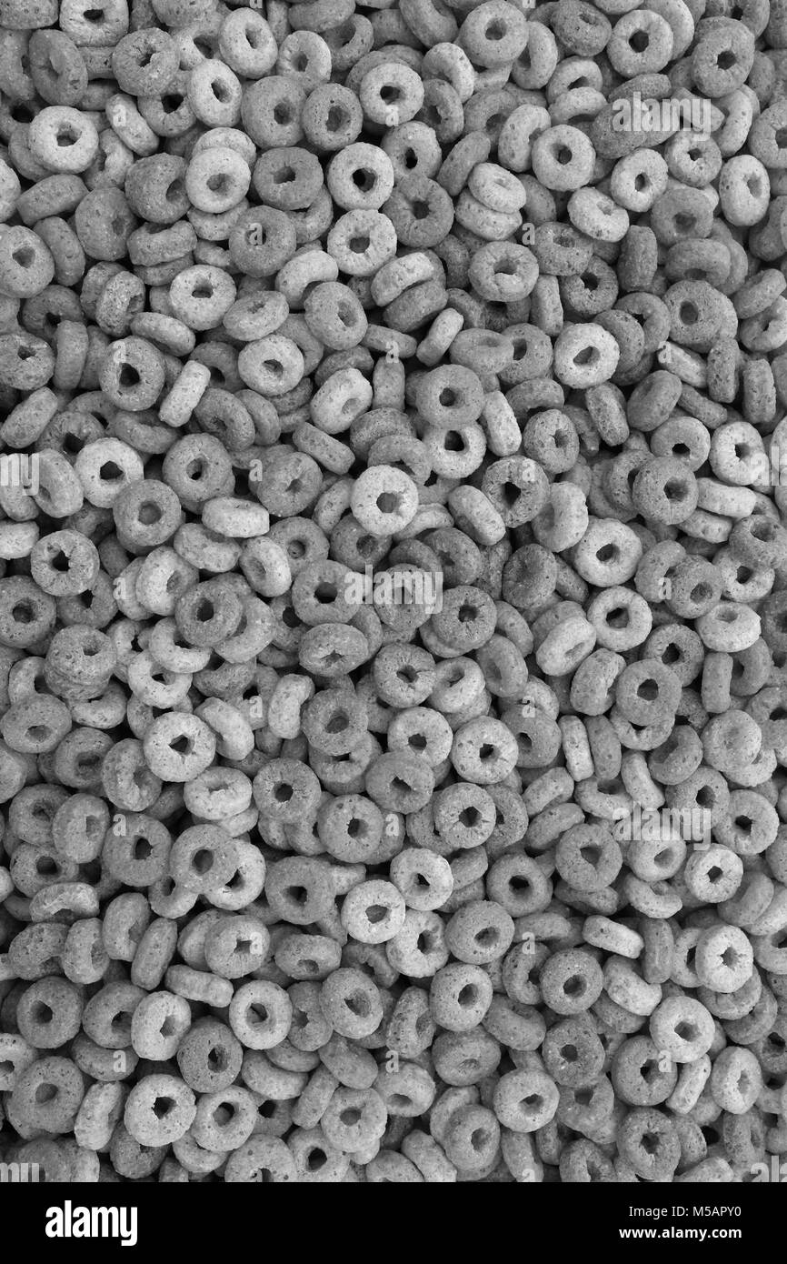 Healthy multigrain hoops breakfast cereal - wheat, barley, rice, oats and maize - as an abstract background texture - monochrome processing Stock Photo