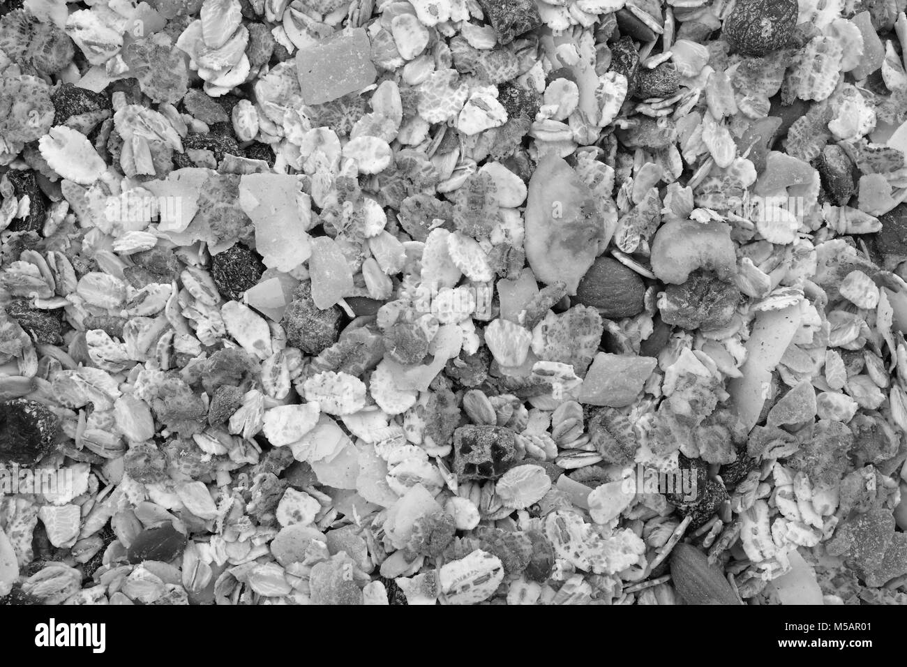 Background of muesli - cereal flakes with seeds, mixed fruit and nuts - as an abstract background texture - close detail - monochrome processing Stock Photo