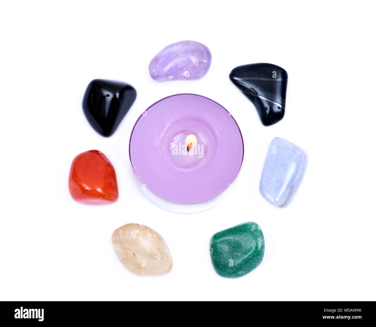Lavender tea light candle surrounded by set of seven healing chakra