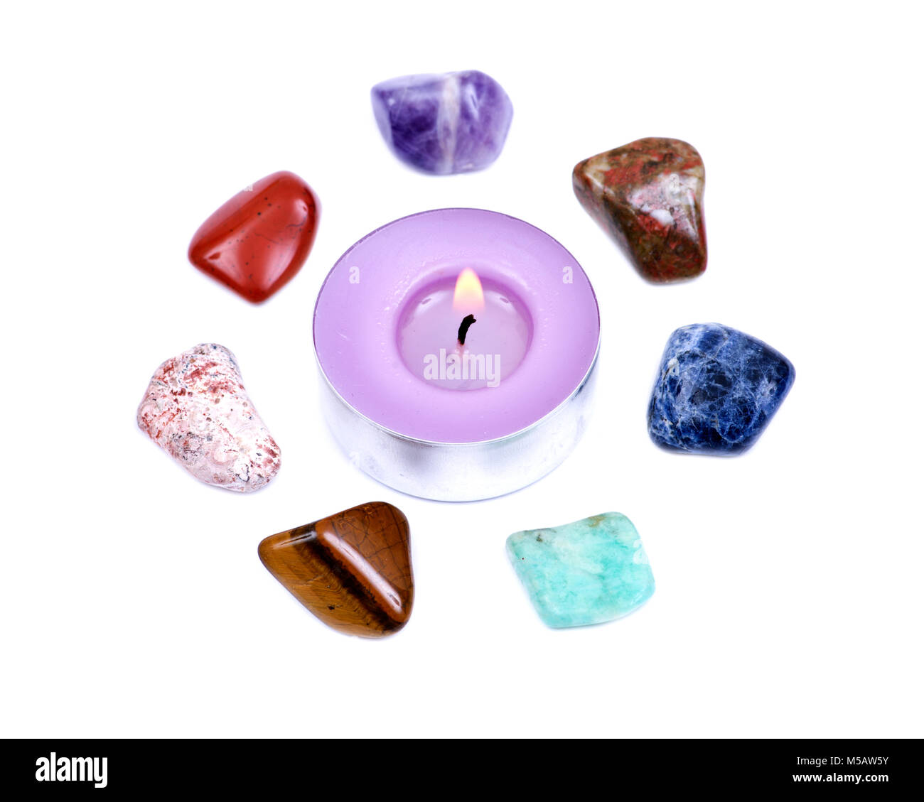 Lavender tea light candle surrounded by set of seven healing chakra