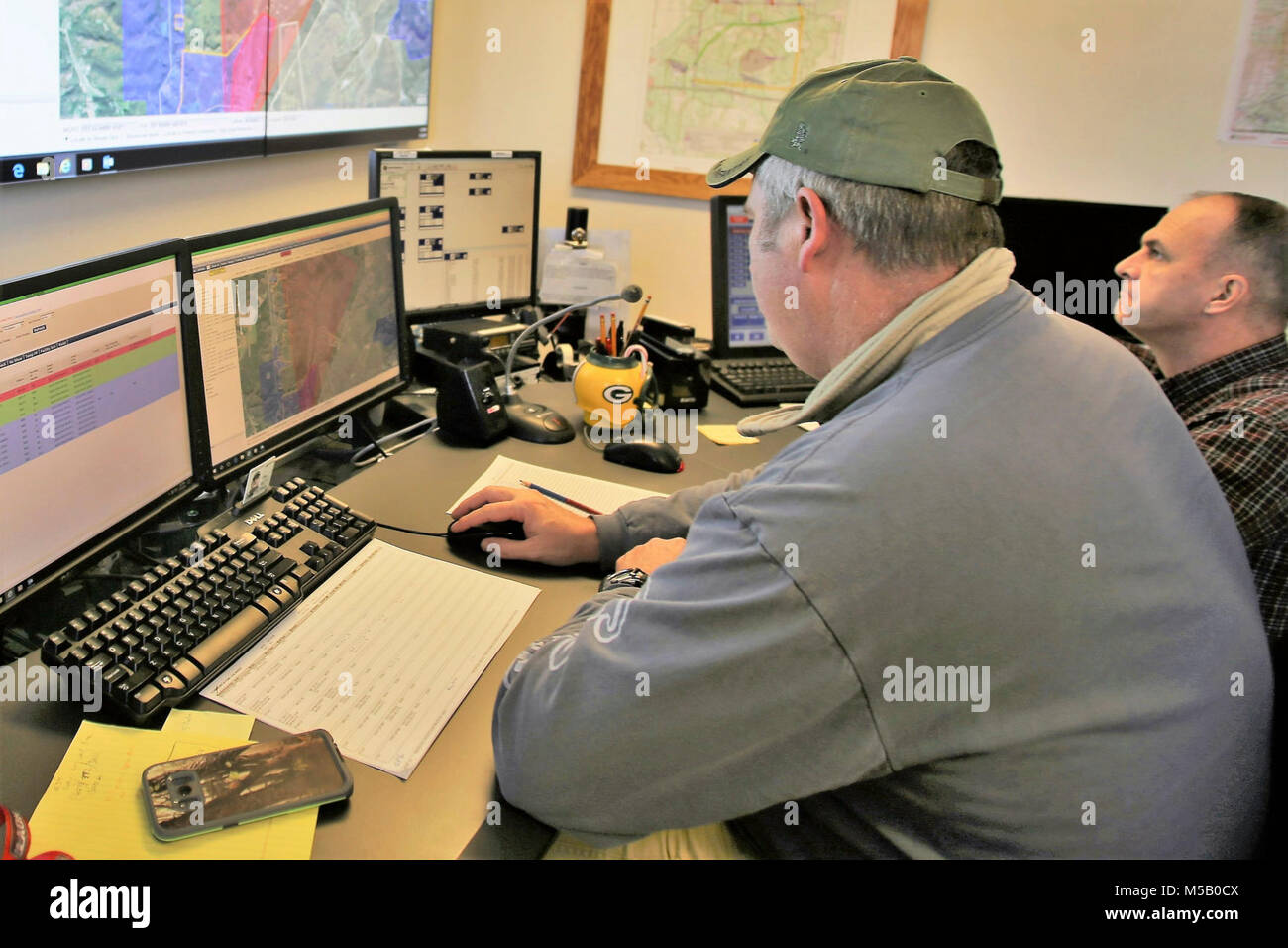 Range Control Technician Mark Confer and Brent Friedl with the Directorate of Plans, Training, Mobilization and Security work developing grid coordinates at the Fire Desk on Jan. 16, 2018, at Fort McCoy, Wis. The desk operates communications with units using the range complex as well as Range Maintenance and other personnel throughout 46,000 acres of training areas on Fort McCoy. (U.S. Army Stock Photo
