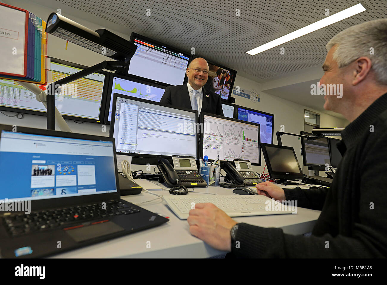 20 February 2018, Germany, Bonn: Arne Schoenbohm (L), President of the Bundesamt für Sicherheit in der Informationstechnik (BSI) (Federal Office for Information Security) speaks to and employee of the Federal Office for Information Security at the national IT centre. Experts warned of the dangers of cyber attacks on authorities in North Rhine-Westphalia. Photo: Oliver Berg/dpa Stock Photo