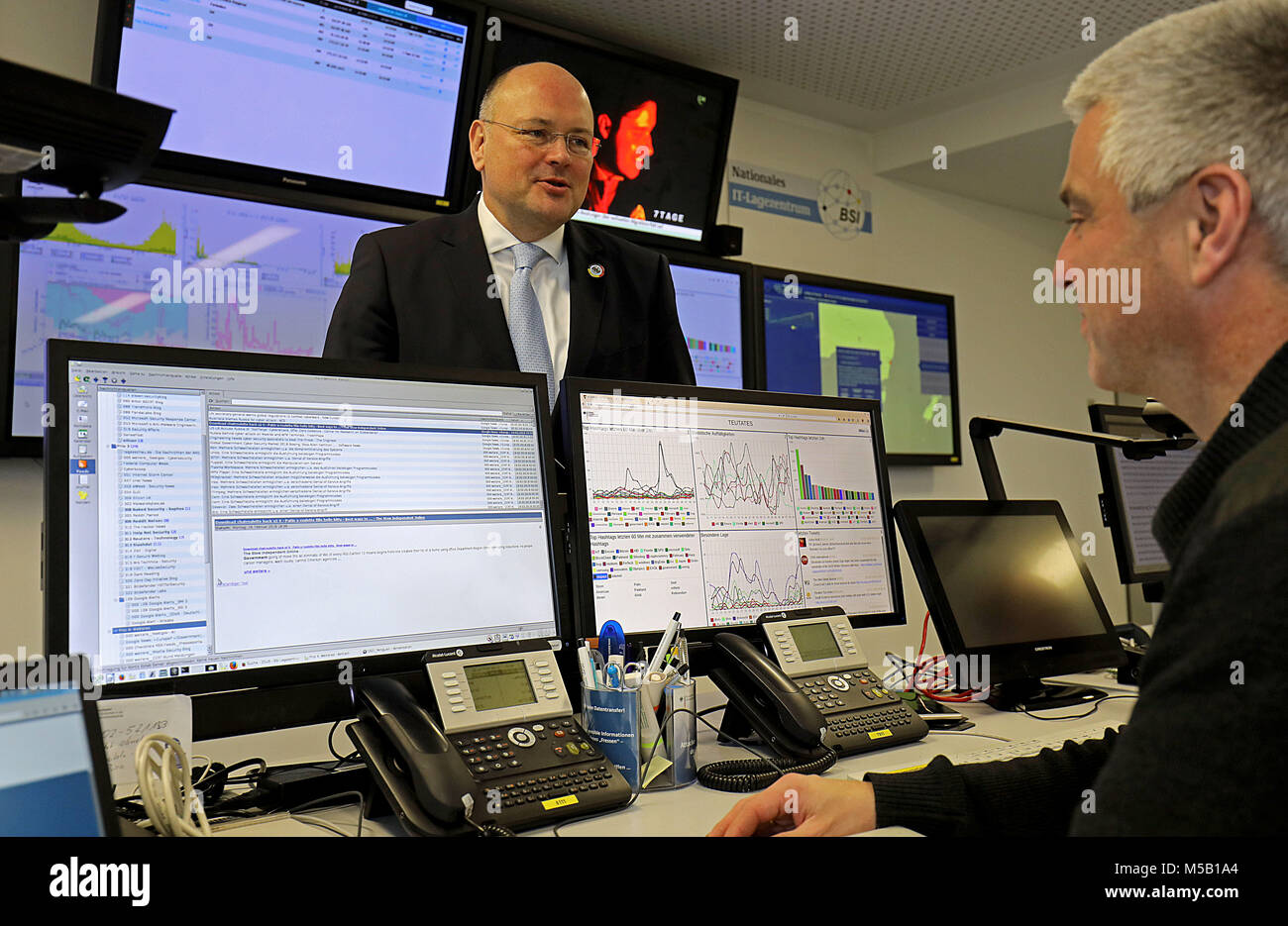 20 February 2018, Germany, Bonn: Arne Schoenbohm (L), President of the Bundesamt für Sicherheit in der Informationstechnik (BSI) (Federal Office for Information Security) speaks to and employee of the Federal Office for Information Security at the national IT centre. Experts warned of the dangers of cyber attacks on authorities in North Rhine-Westphalia. Photo: Oliver Berg/dpa Stock Photo