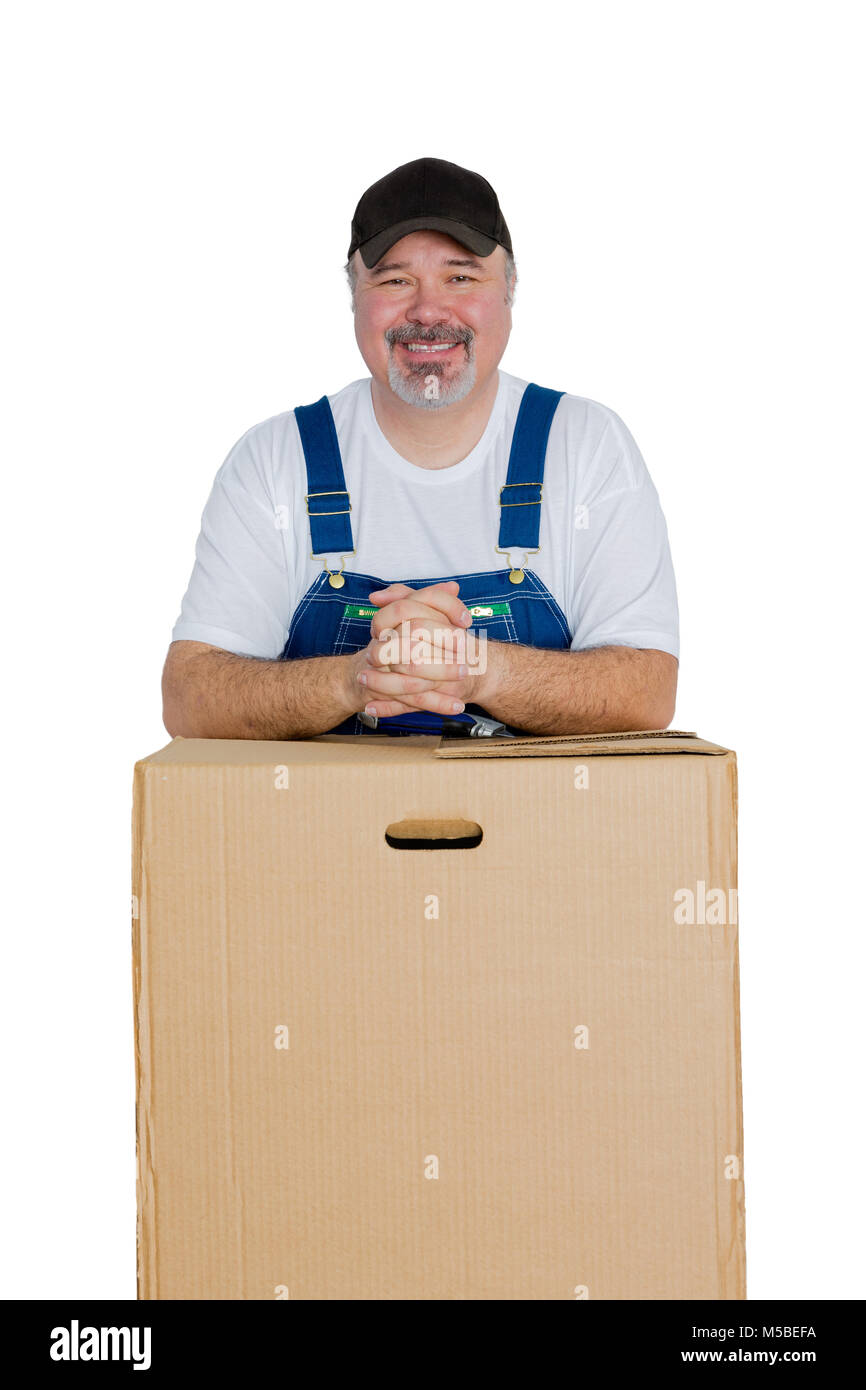 Portrait of smiling man leaning against large cardboard box on white background Stock Photo