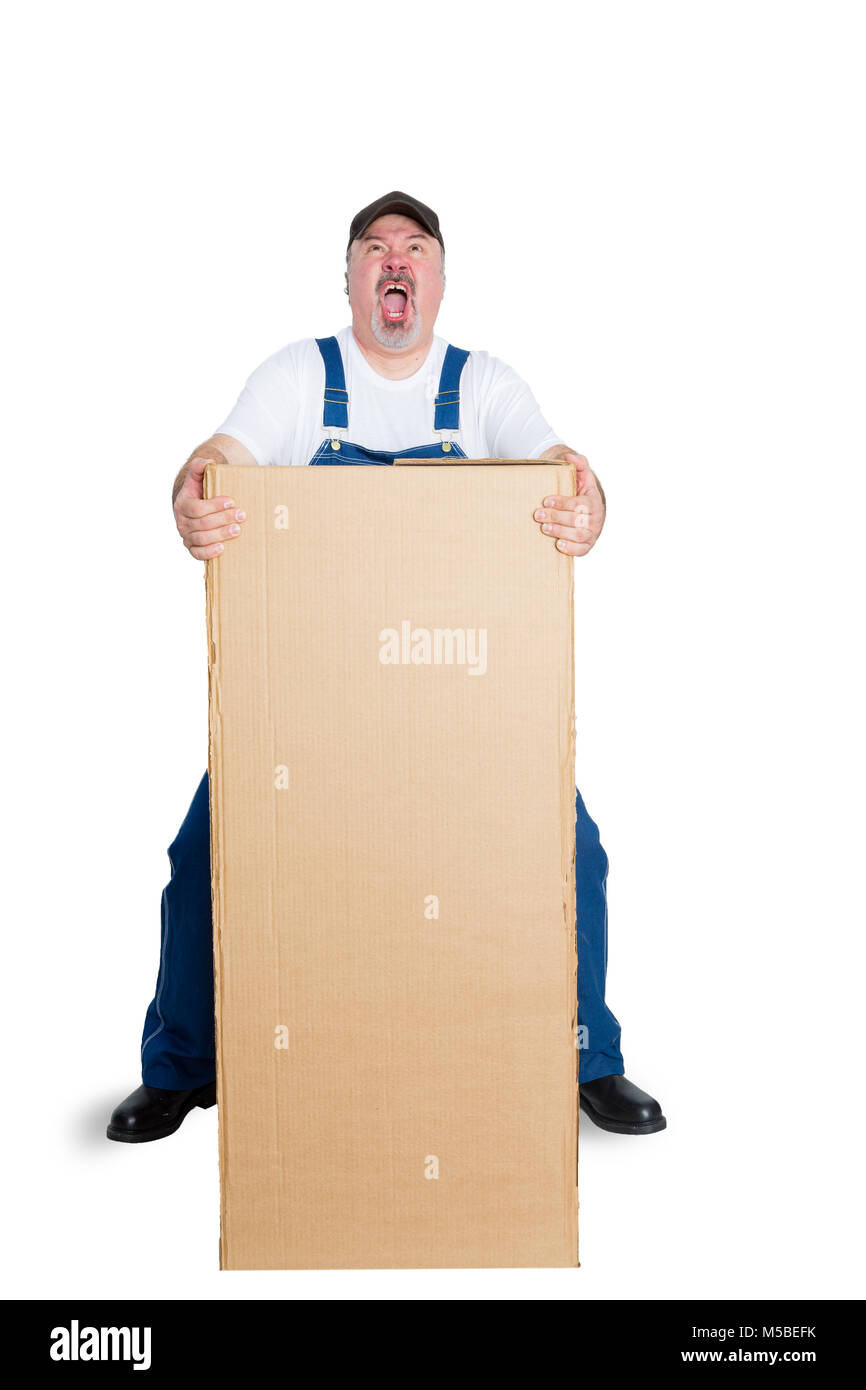 Man wearing dungarees lifting heavy big package against white background Stock Photo