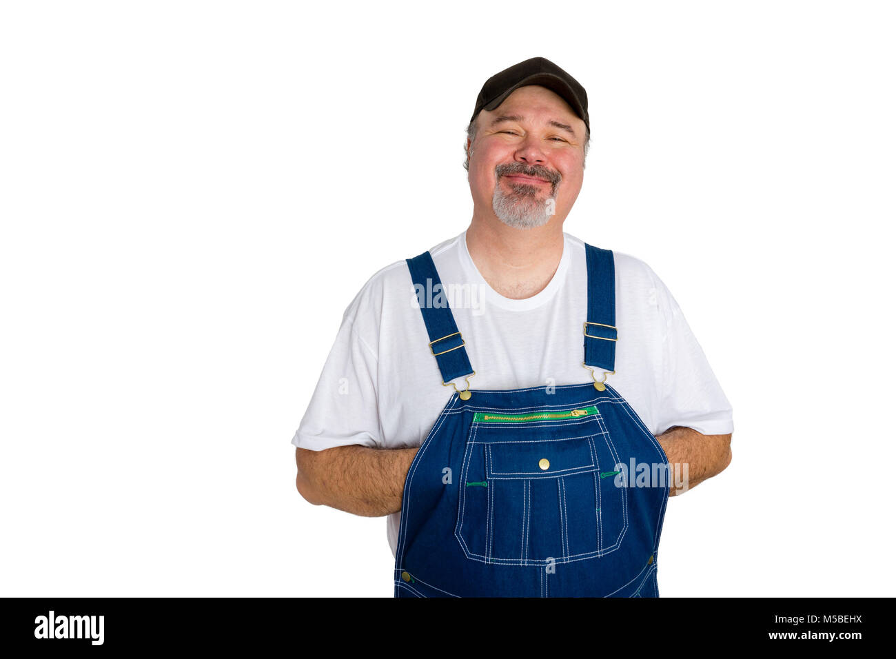 Portrait of cheerful man wearing dungarees against white background Stock Photo