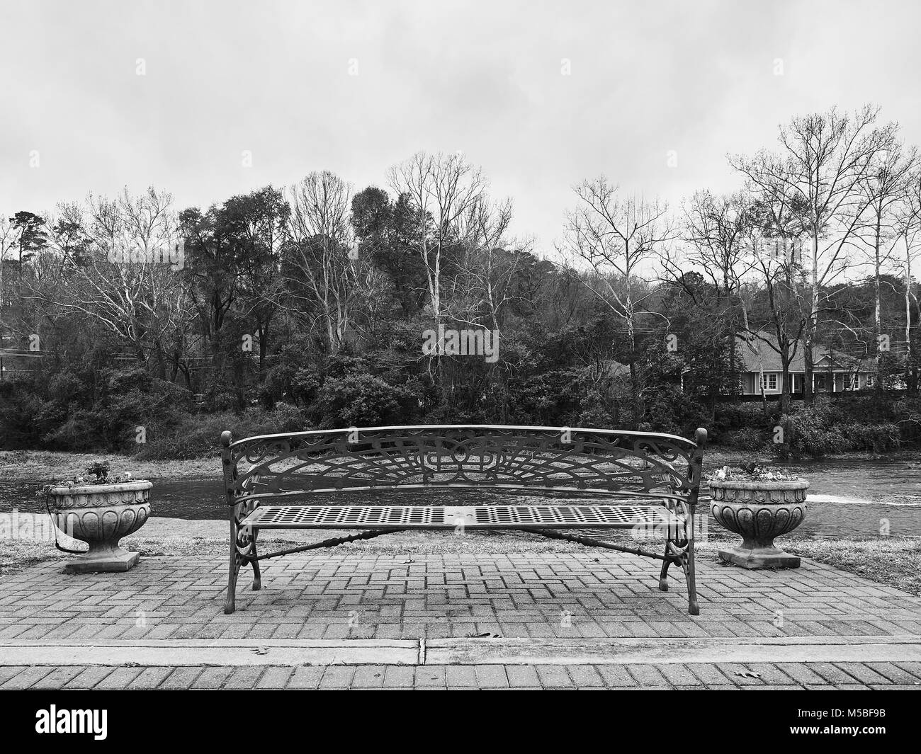 Unoccupied city park bench overlooking Autauga Creek with copy space, in Prattville Alabama, USA. Stock Photo