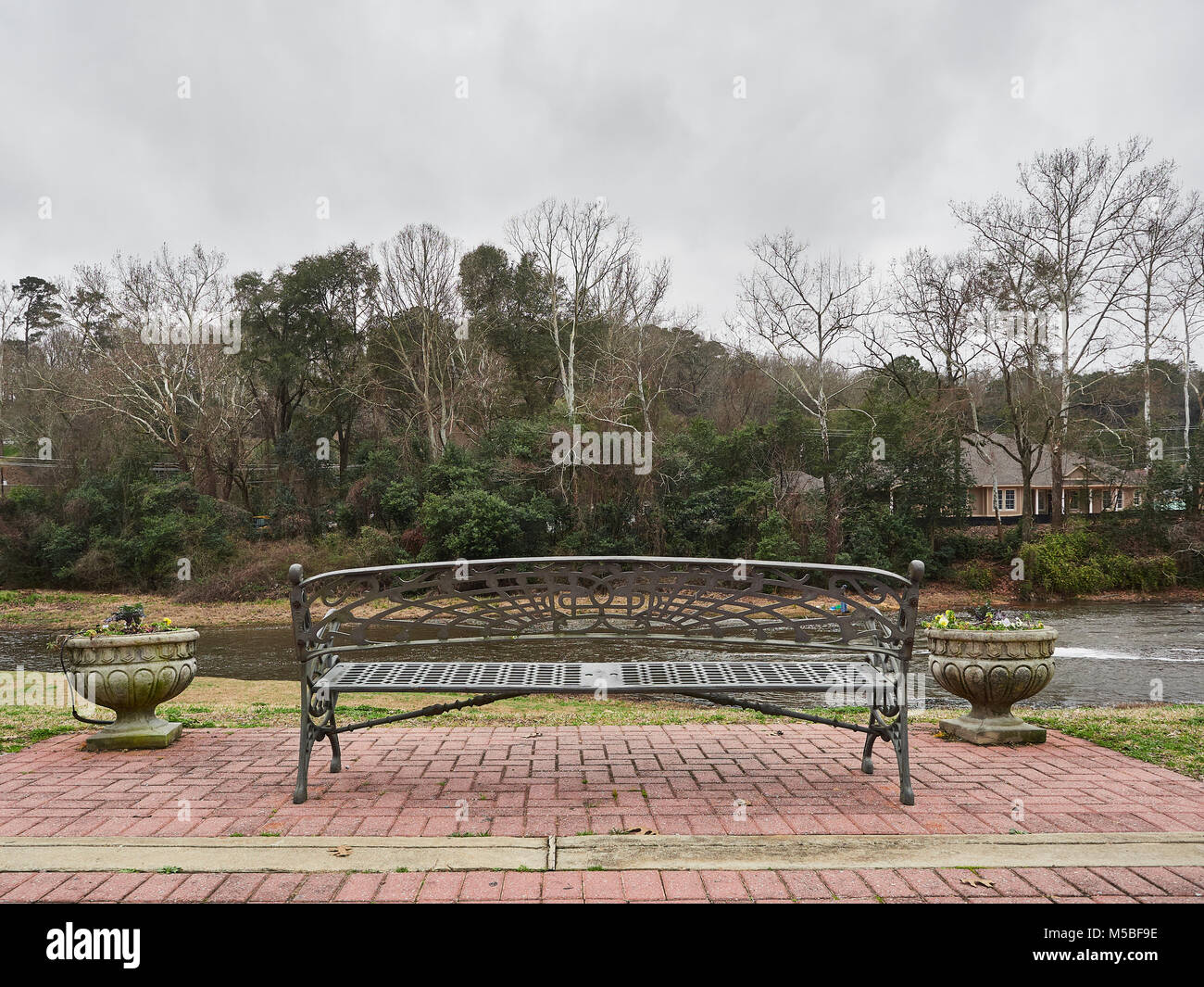 Unoccupied city park bench overlooking Autauga Creek with copy space, in Prattville Alabama, USA. Stock Photo