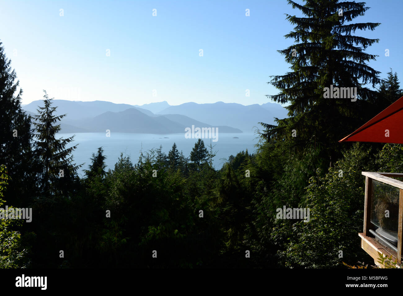 A view of Howe Sound and the mountains of Gambler Island and the mainland coast in silhouette, seen from Lions Bay, British Columbia, Canada. Stock Photo