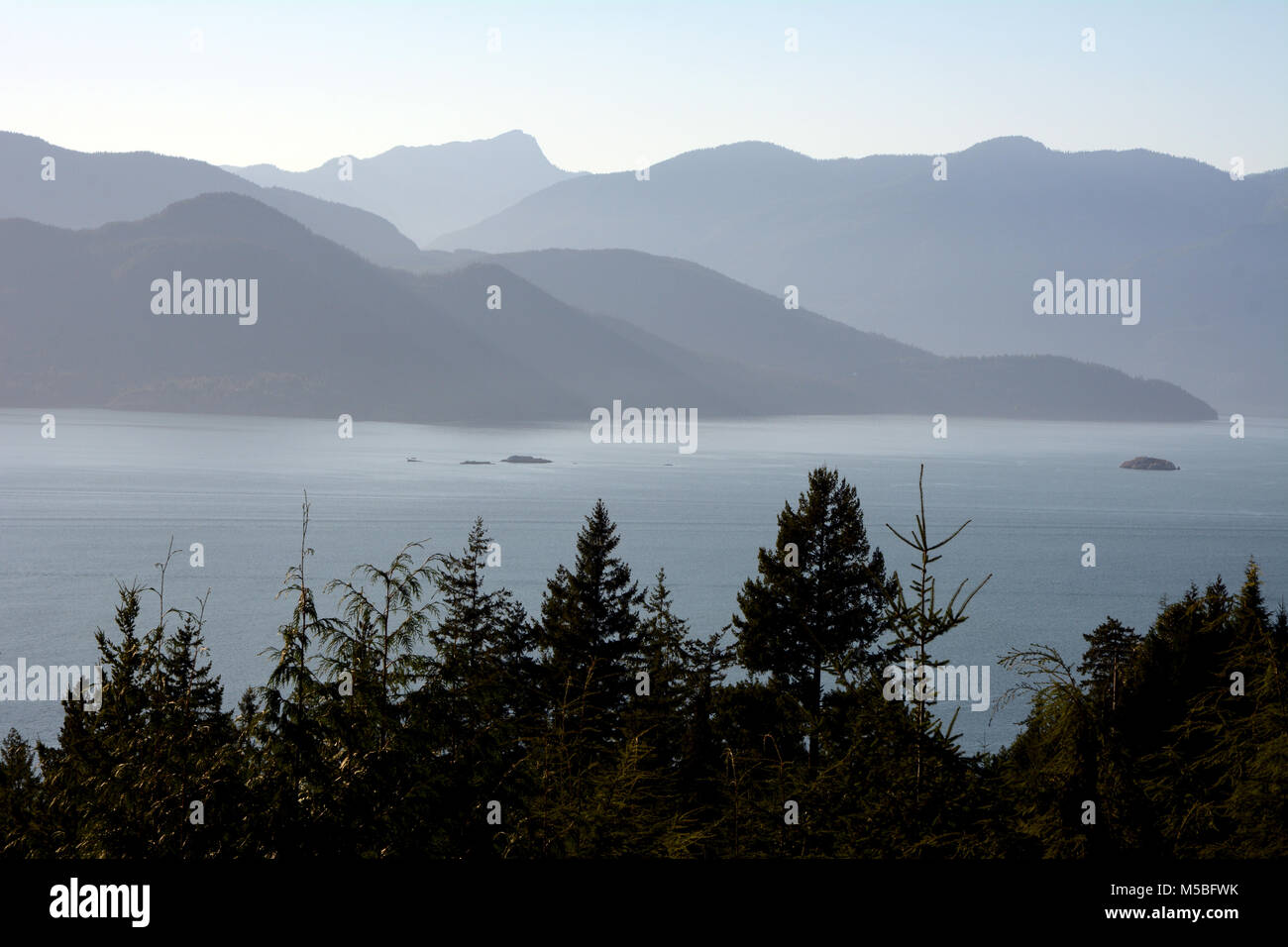 A view of Howe Sound and the mountains of Gambler Island and the mainland coast in silhouette, seen from Lions Bay, British Columbia, Canada. Stock Photo