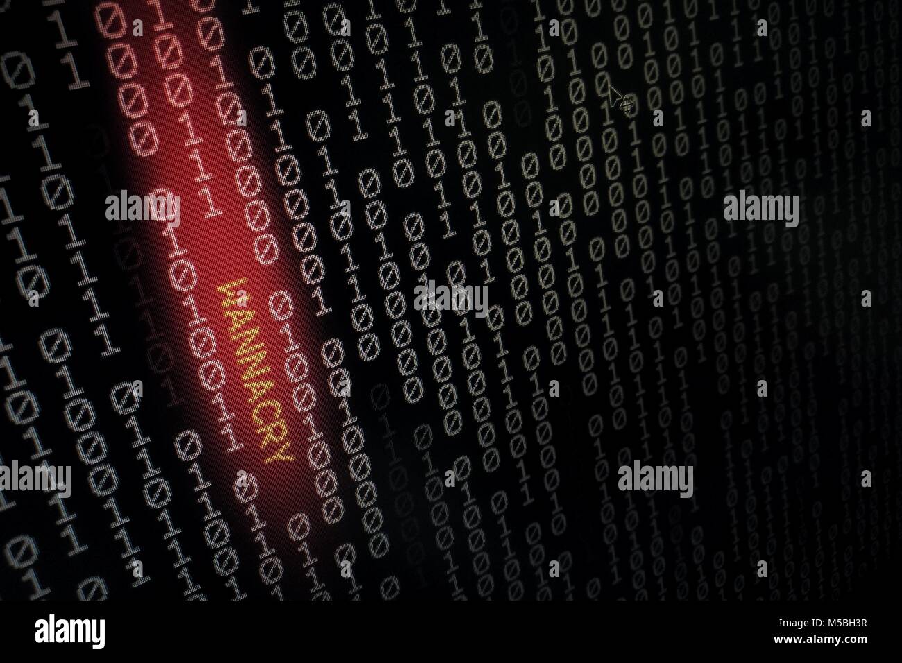 computer virus. binary data shown on black screen with wannacry text hilight with red colour. Stock Photo