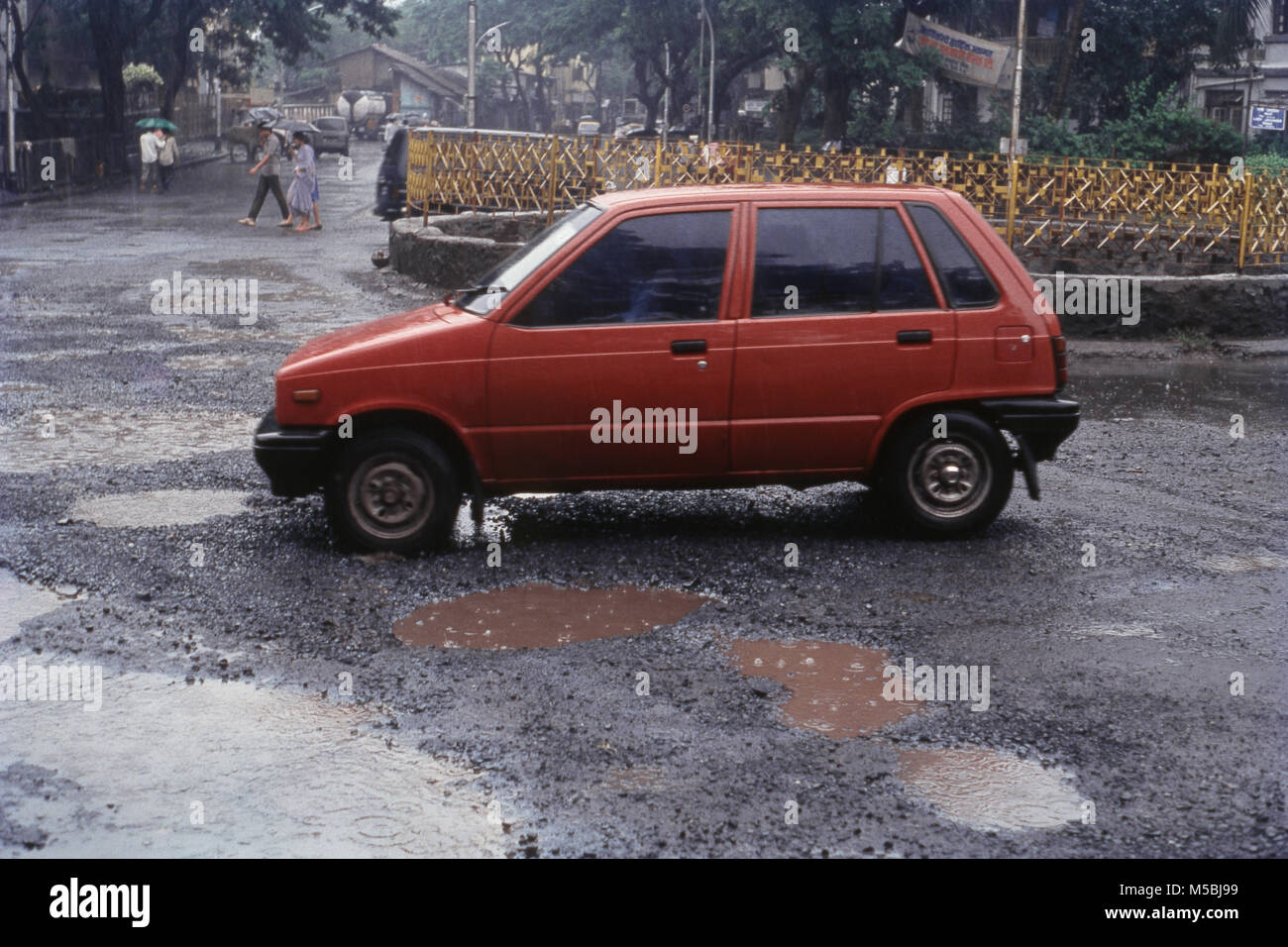 Side view of Maruti car going through potholes, Mumbai, India Stock Photo