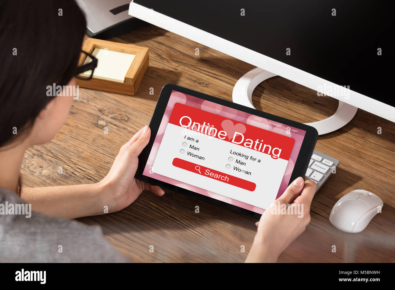 Woman Using Online Dating Website On A Digital Tablet Stock Photo