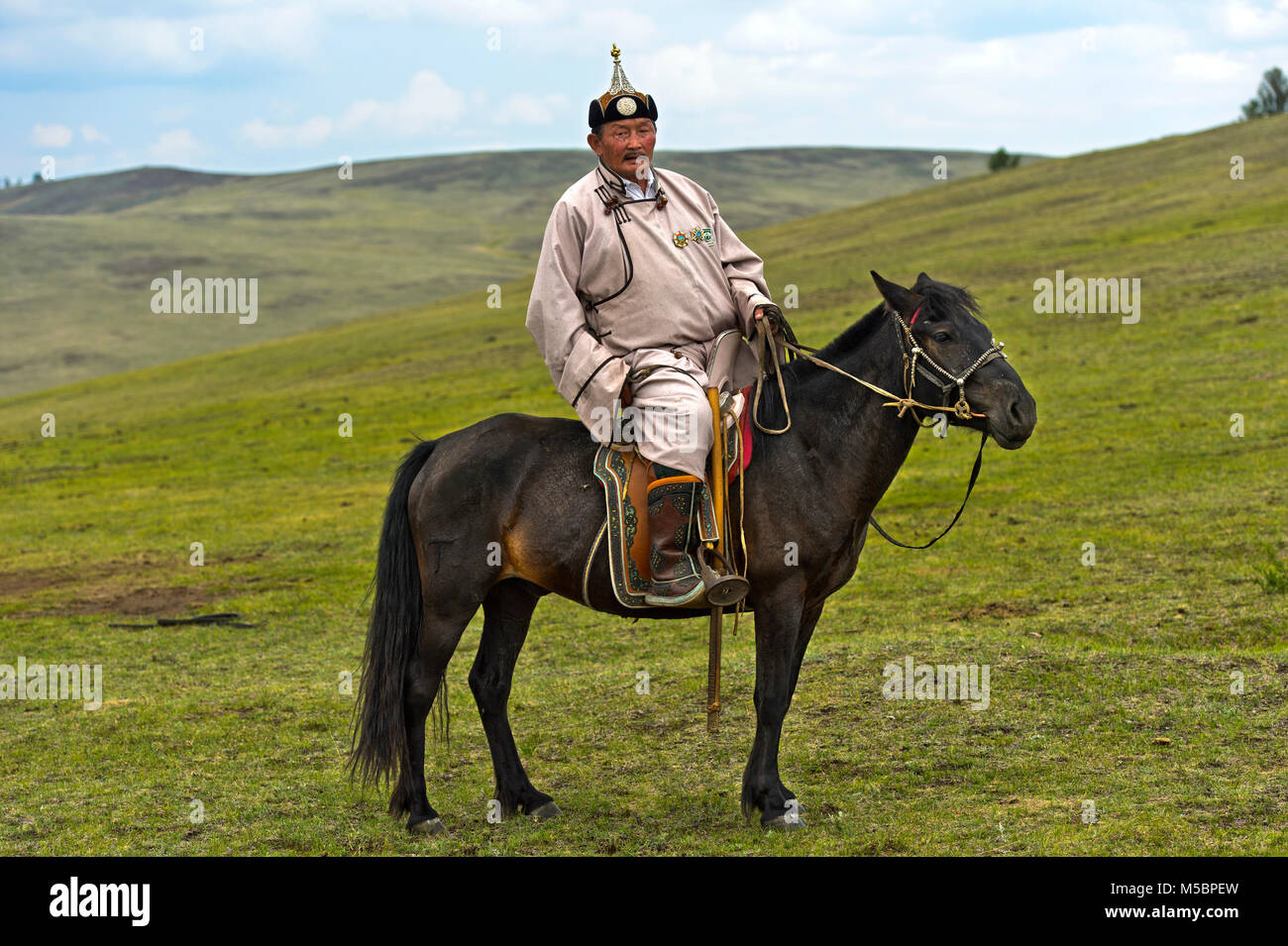 Elderly male nomad in traditional dress riding a horse in the steppe, near  Erdenet, Mongolia Stock Photo - Alamy