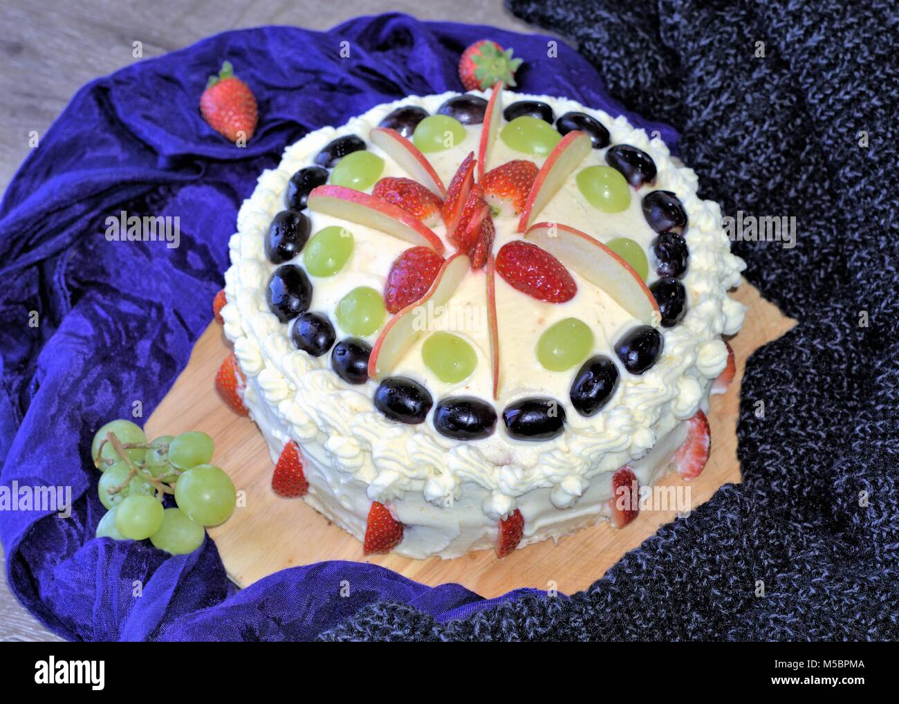 Cake topped with fruits. Fruit cake with cream, apple slices