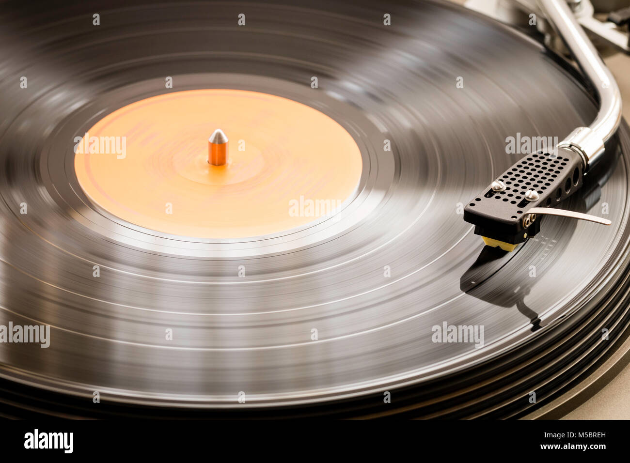 Record player deck, turntable, with 33 rpm, LP, record being played. Tone arm is an S-sharp. Stock Photo