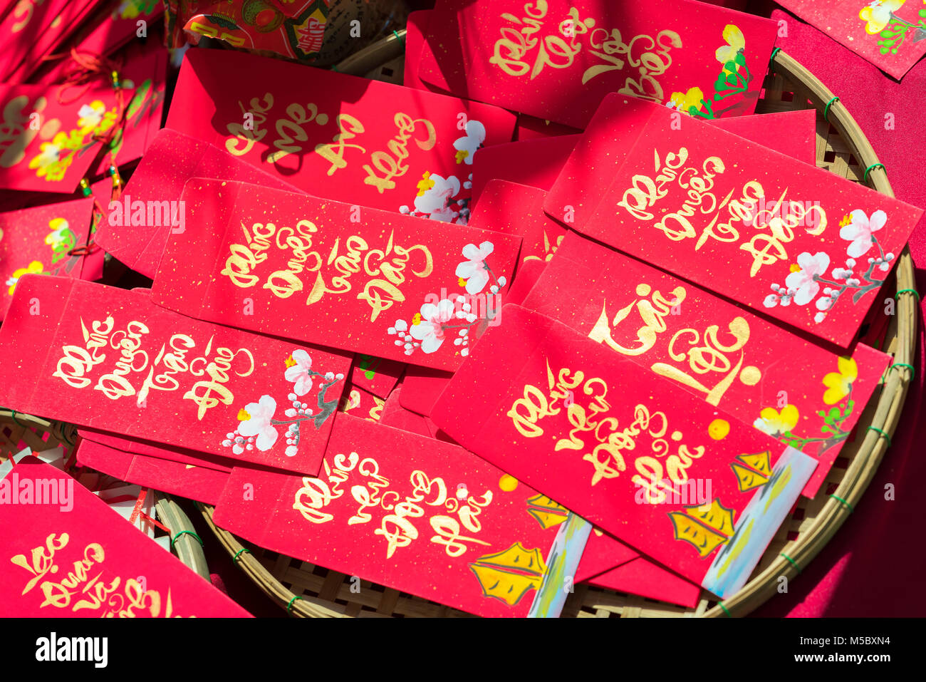 Red envelopes Lunar New Year Calligraphy decorated with text 'Merit, fortune, longevity' in Vietnamese means anyone receives money from envelope Stock Photo