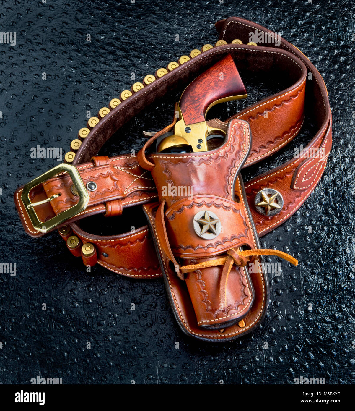 Old cowboy 45 pistol and leather tooled holster. Stock Photo
