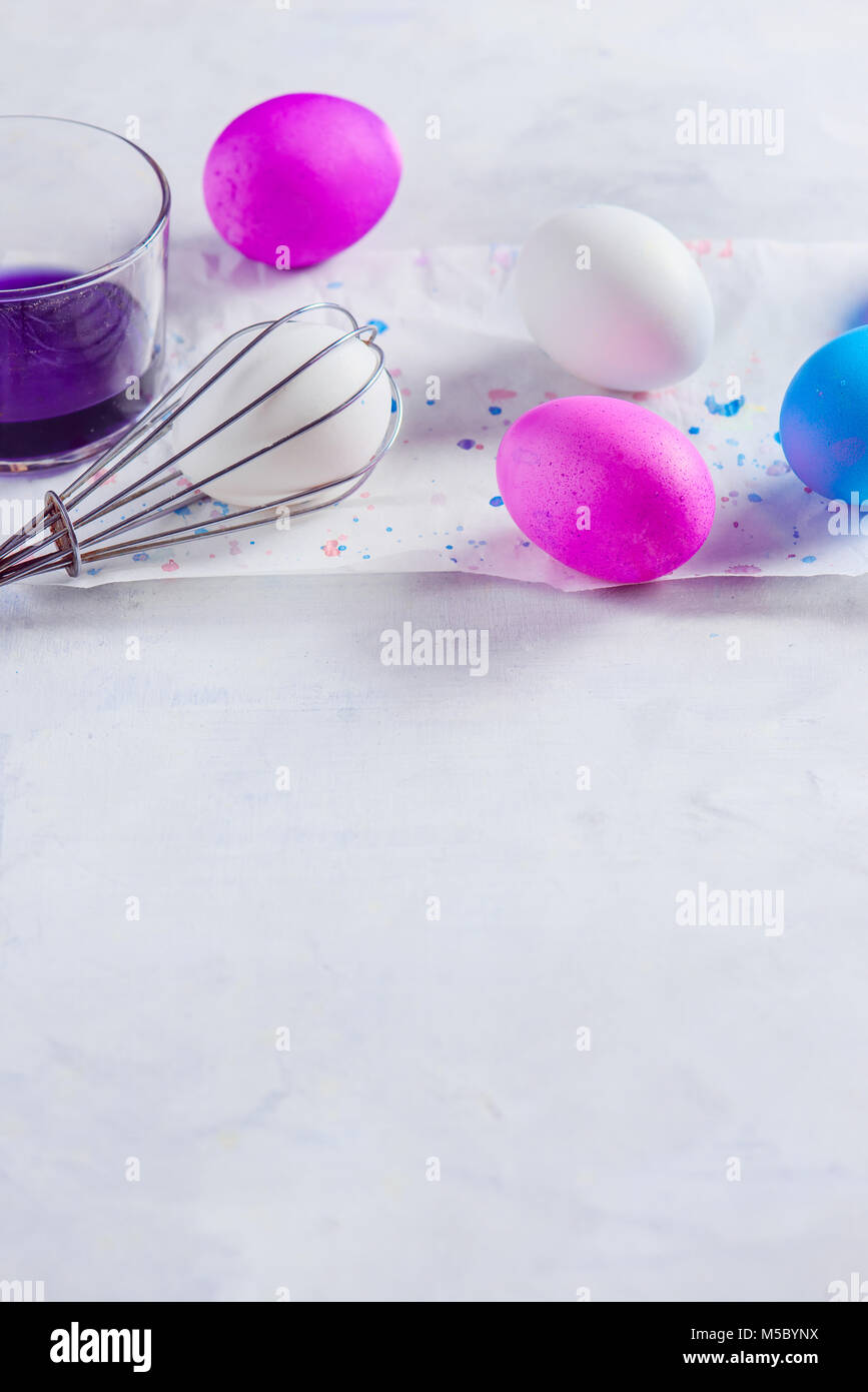 Painting Easter eggs using a whisk. Holiday lifehack with copy space. Minimalist Easter decorations Stock Photo